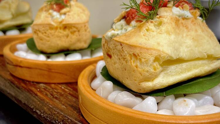 Three puff pastries with herbs on top