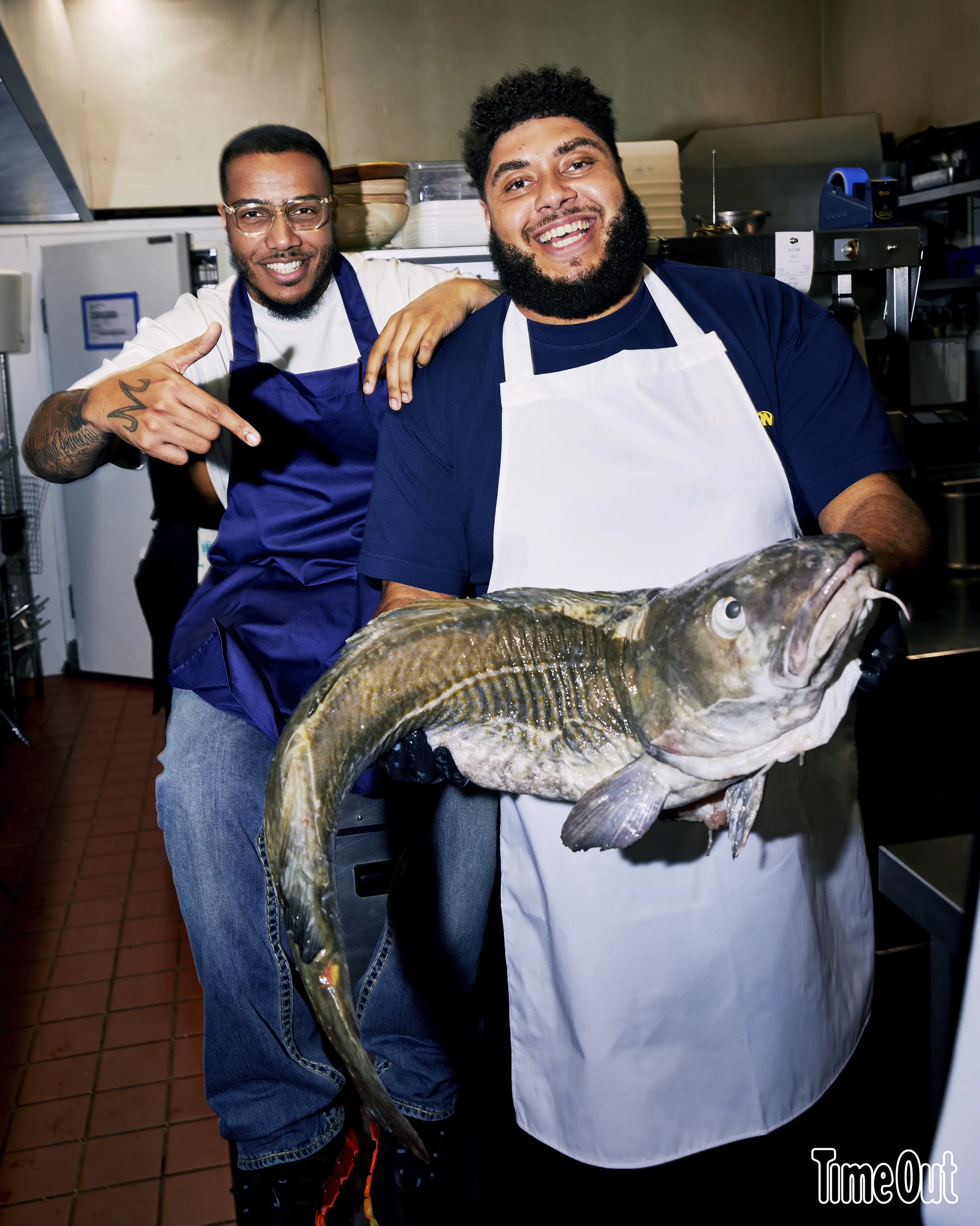 Big Zuu and AJ Tracey in the kitchen with a fish