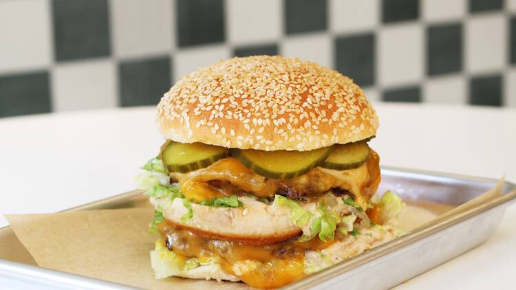 A double stacked burger on a metal tray