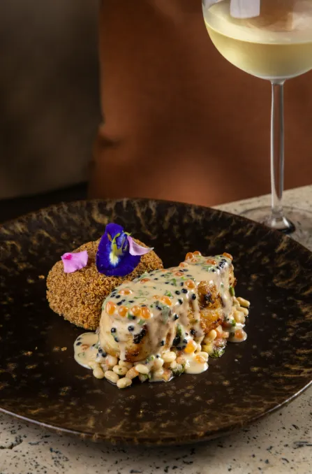 O robalo chega confitado, encostado em croquete de banana, saladinha de feijão Santarém e tucupi com ovas