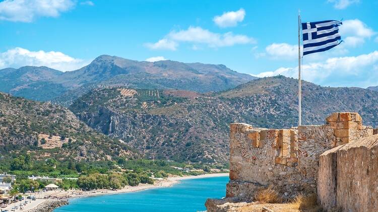 Crete with Greece flag and mountains in background