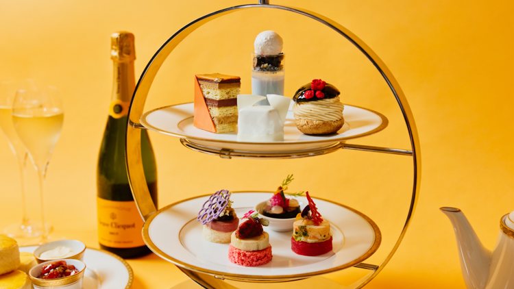 a serving of high tea sweets and champagne in the  background 