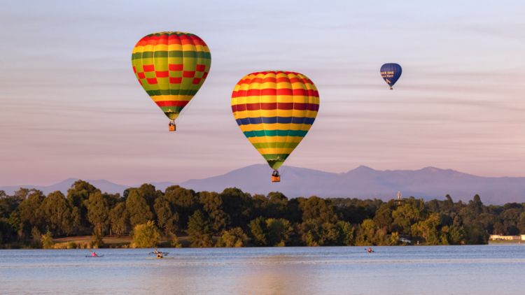 Hot air balloons over lake