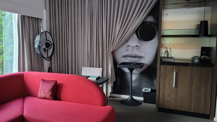 A hotel room with a bright red couch