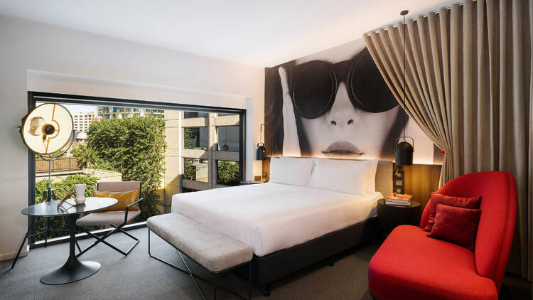A hotel room with a photo of a woman in sunglasses on the wall