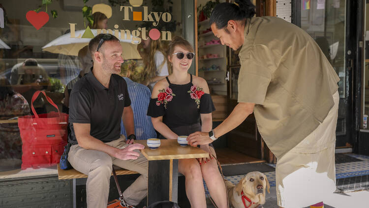 Waiter serving a man and a woman with her Guide Dog