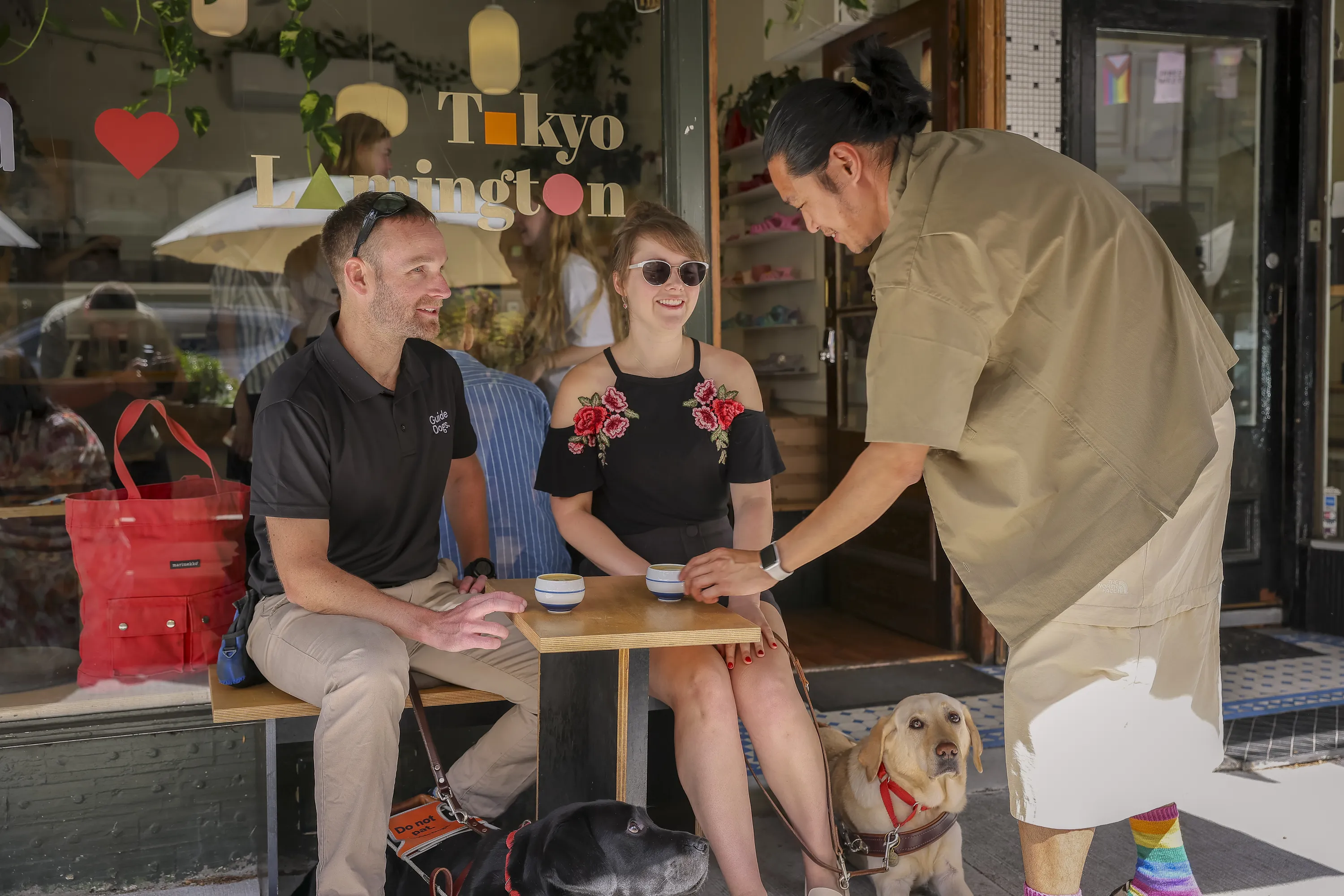Waiter serving a man and a woman with her Guide Dog