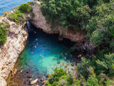 People bathing in Sorrento at Regina Giovanna Queen's bath - Tourists swimming in crystal clear blue waters of popular lagoon on Amalfi Coast. Italy People bathing in Sorrento at Regina Giovanna Queen's bath - Tourists swimming in crystal clear blue waters of popular lagoon on Amalfi Coast. Italy