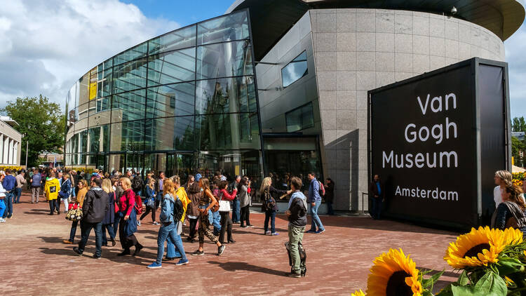 crowd in front of the new wing of the Van Gogh Museum with sunflowers in the foreground