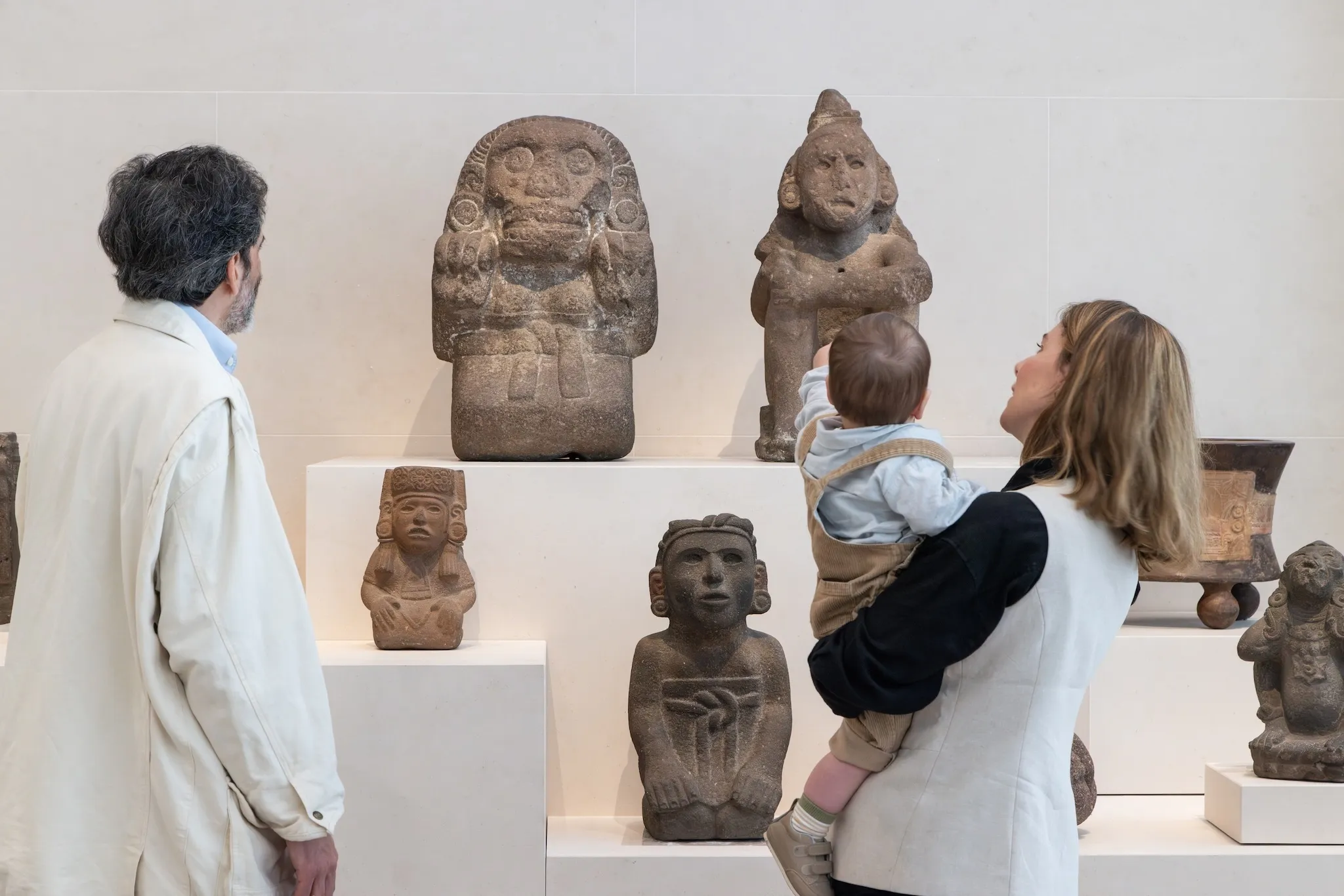 A family looks at Mexican sculptures.