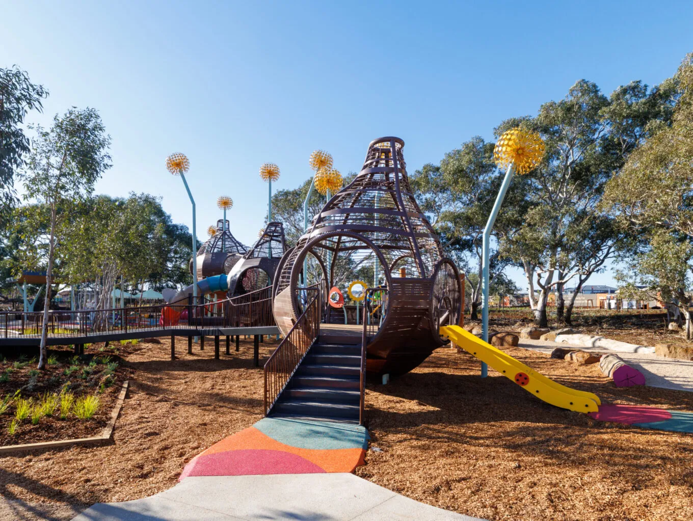A playground with colourful features and giant flower sculptures.