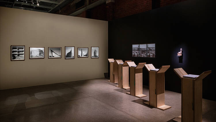 Installation view showing photographs by David Goldblatt at left and . Matri-archi(tecture), Building Africa: The State of Things! (2023) installation at right. 