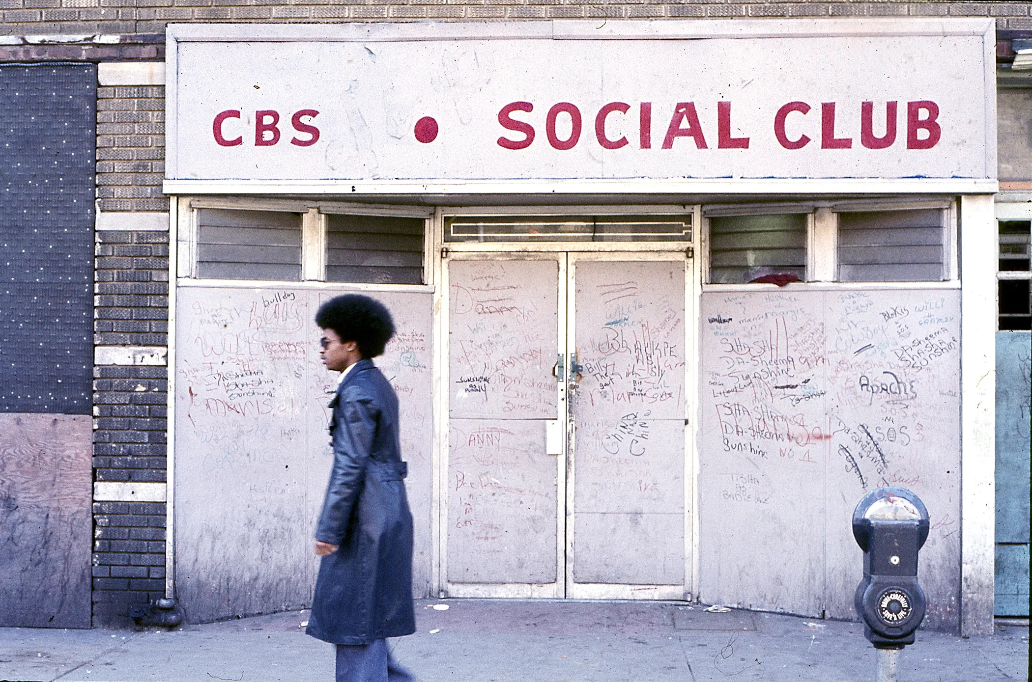 A man walks past the closed and boarded up CBS Social Club, Mermaid Avenue, 1974