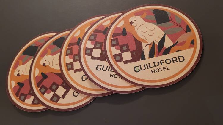 coasters with the words GUILDFORD HOTEL and a cockatoo