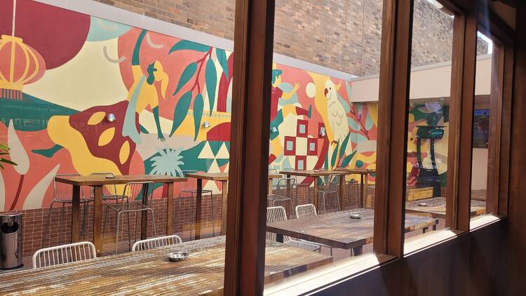 A beer garden with a colourful mural of a cockatoo