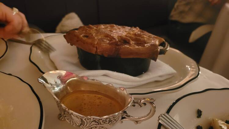 A pie and gravy boat on a table