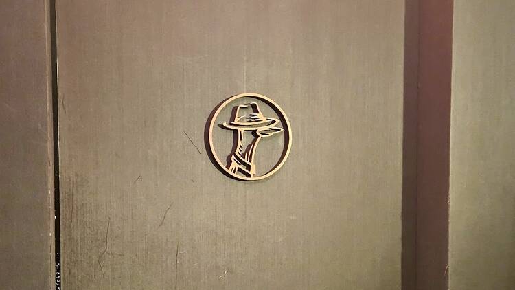 A logo with a duck with a detective's hat on on a door
