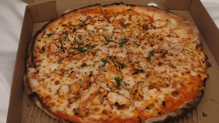 A Lebanese pizza with cheese and chicken