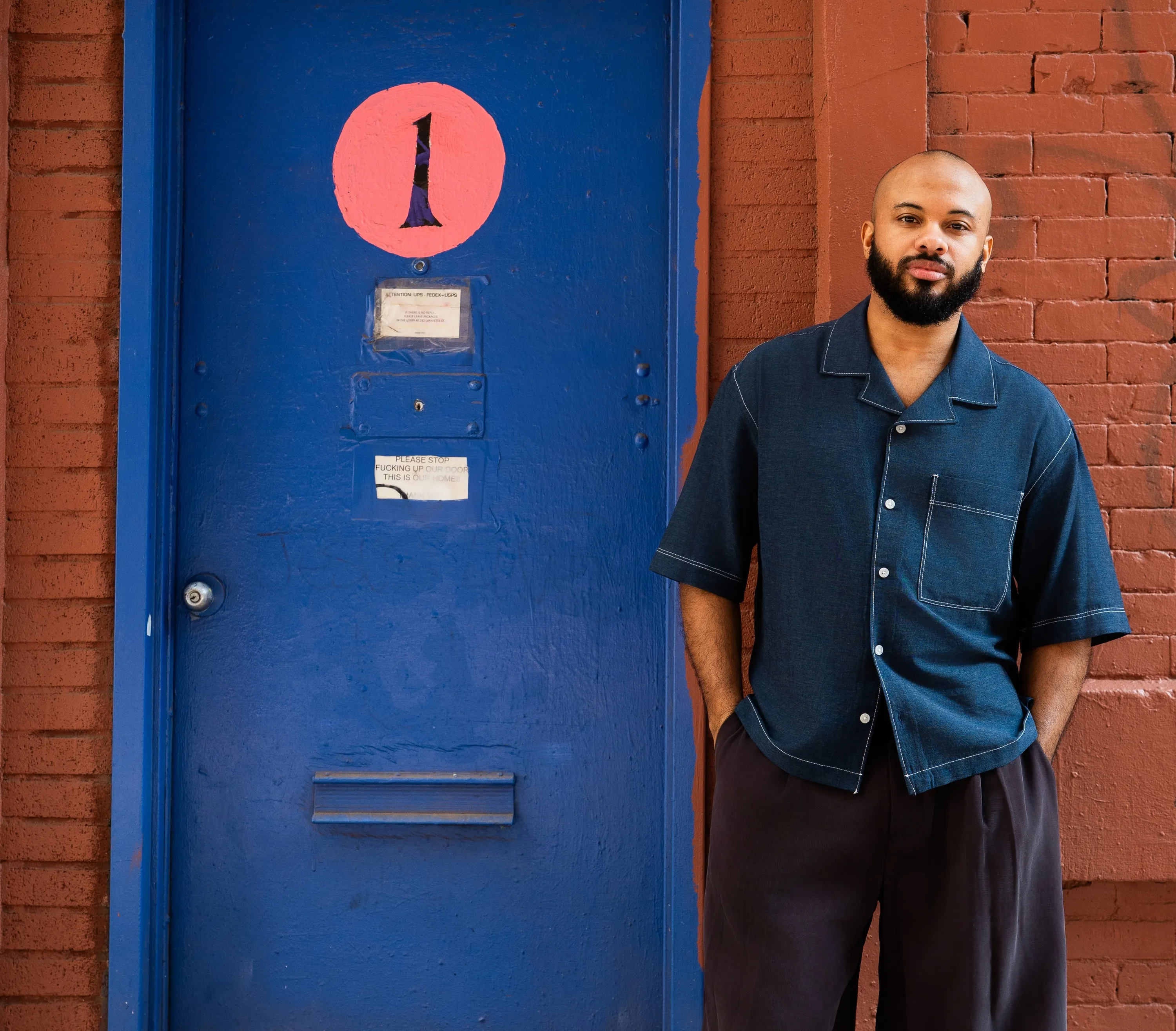 DJ LSJ standing outside of a blue door