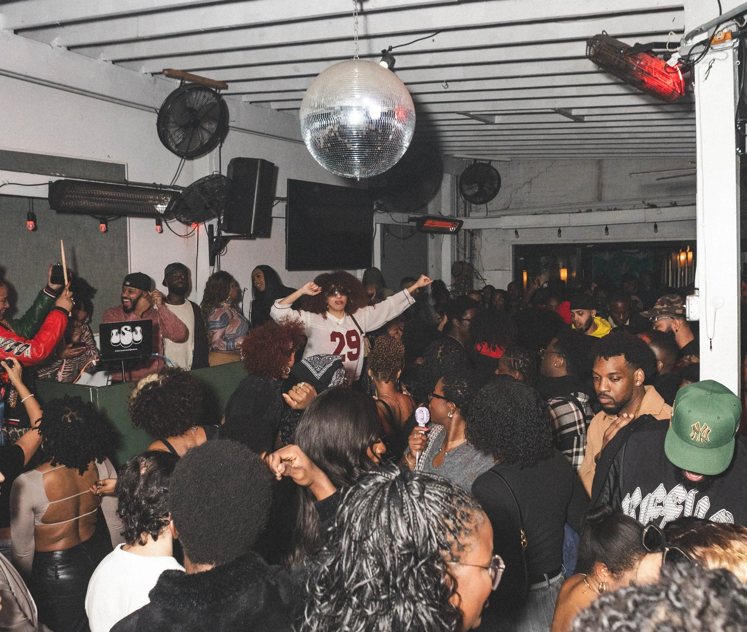 People dancing in a room with a disco ball
