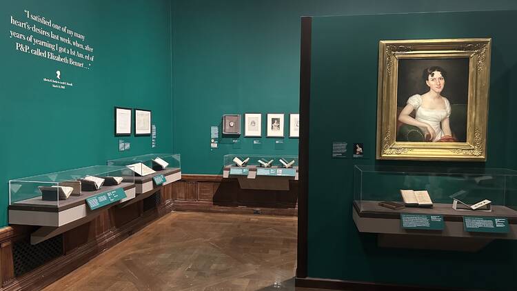 An exhibit about Jane Austen with green walls and letter on display. 