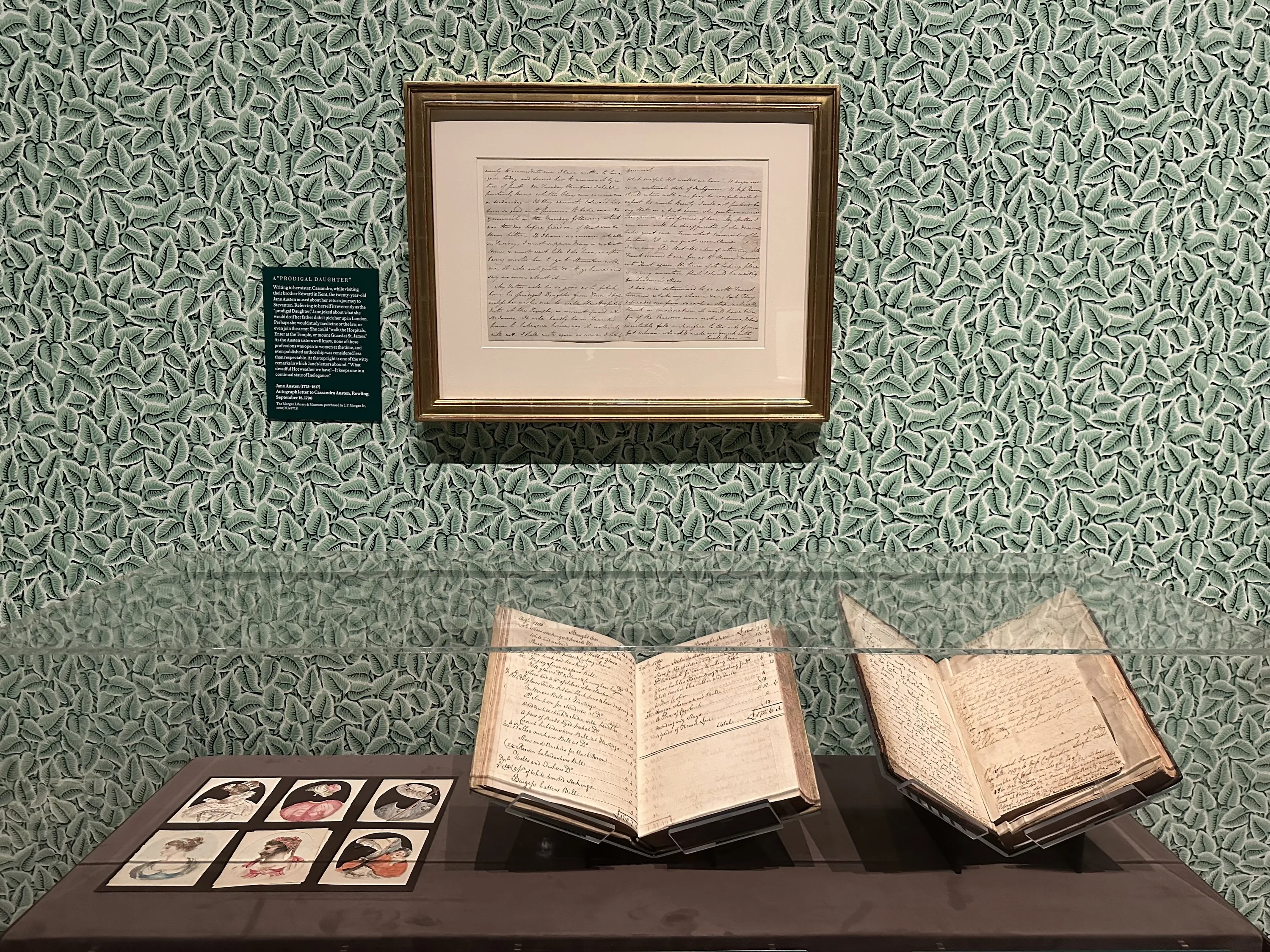 An exhibit about Jane Austen with green walls and letter on display.