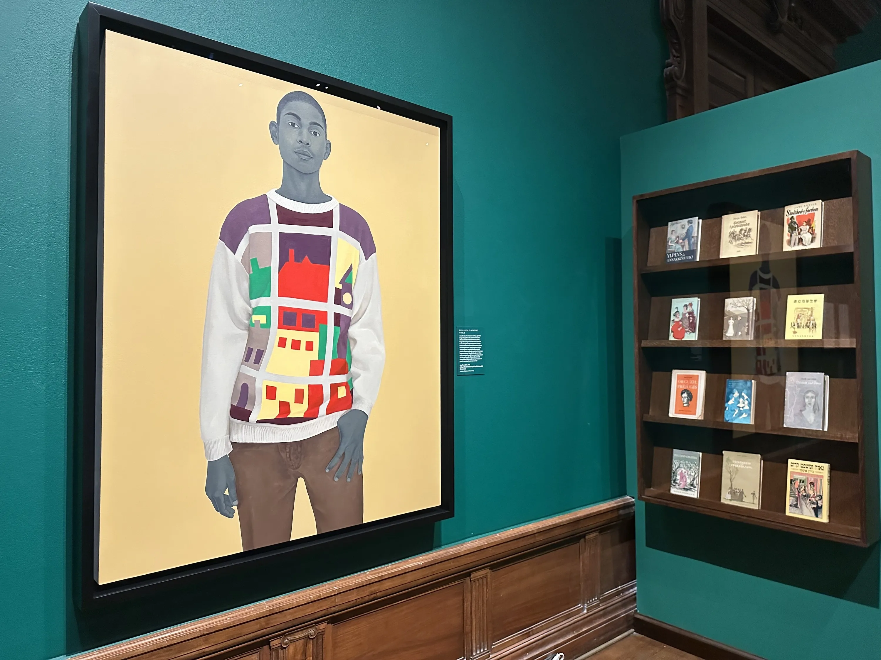 An exhibit about Jane Austen with green walls and a painting on display.