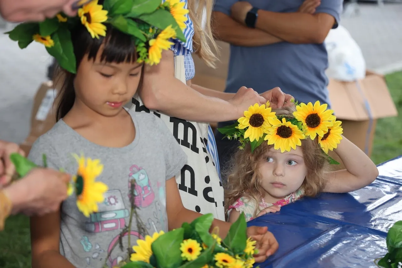 Kids wear crowns made of sunflowers.