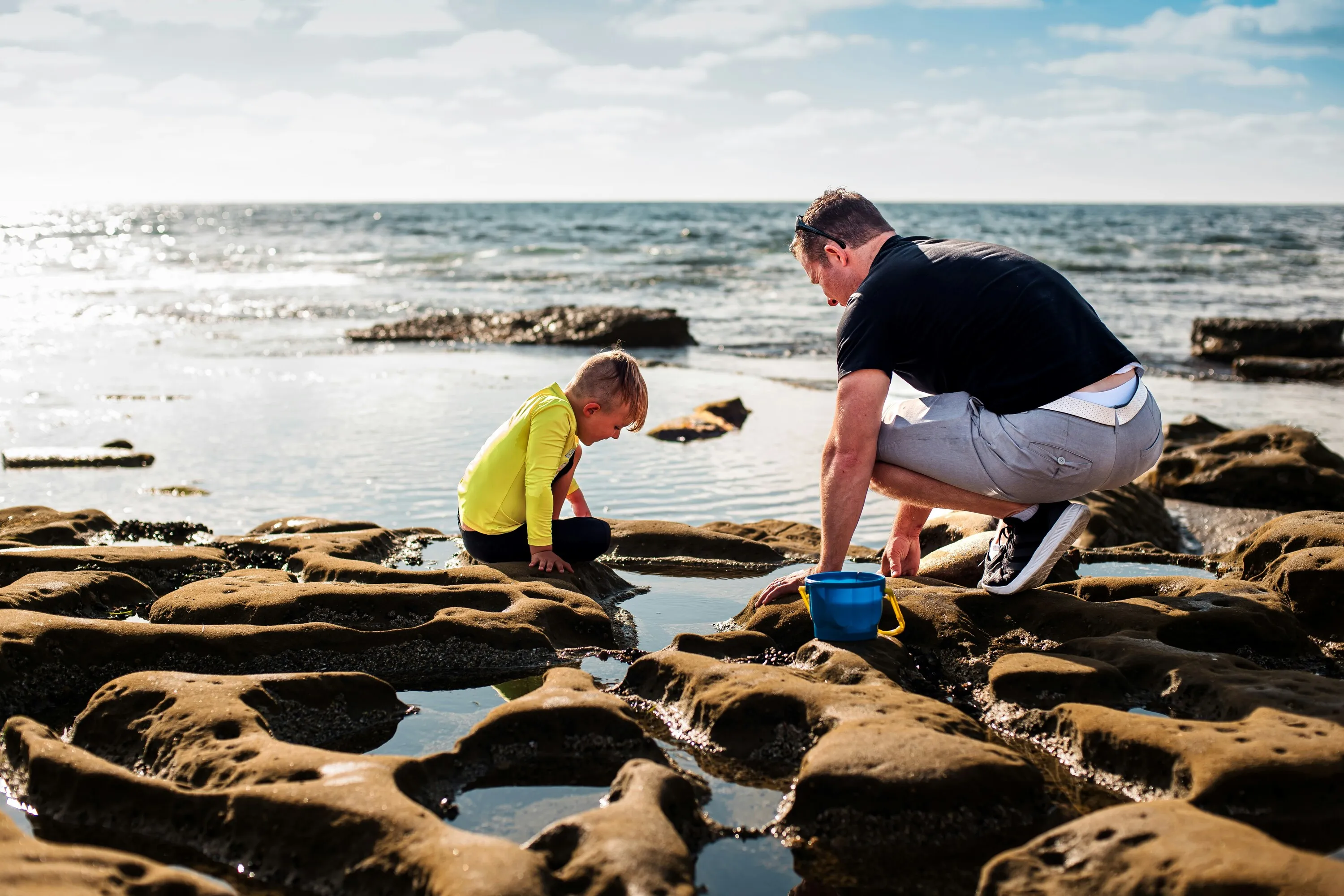 Man and boy playing in rock pools