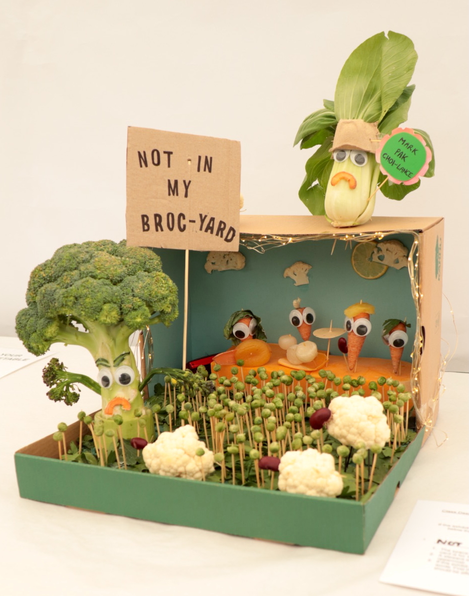 Vegetable artwork showing an angry broccolli with a sign saying ‘not in my broc-yard’