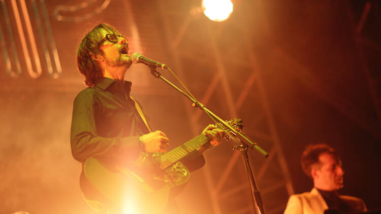 Jarvis Cocker on stage with a guitar 