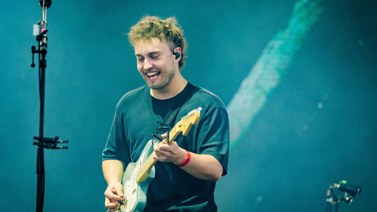 Sam Fender with a guitar on stage 