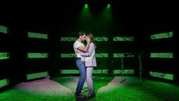 Two actors embrace on stage in 'Heartbreak Hotel'.