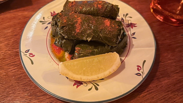 Stuffed vine leaves with a wedge of lemon.