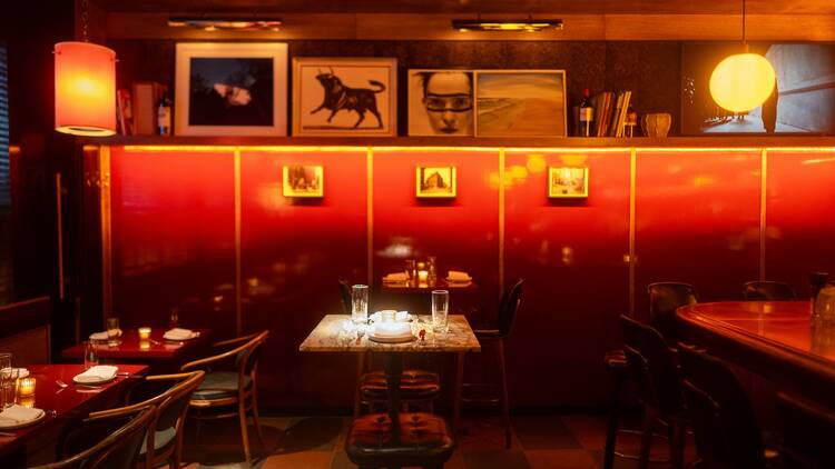 The interior of Bar Mercer with red walls and black and white photography on the walls