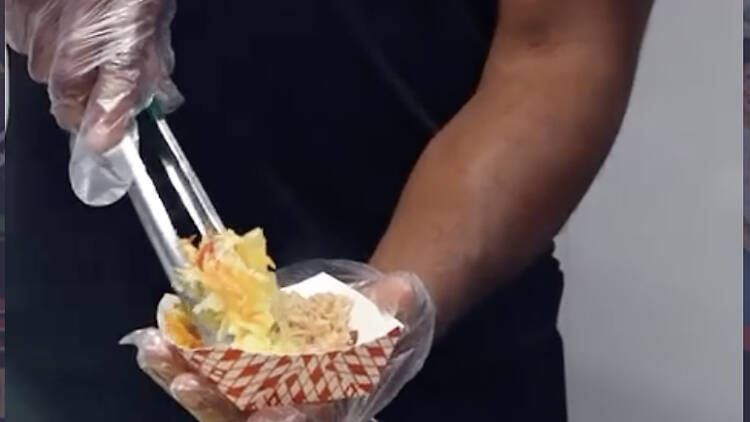 person's hands putting food into a container person's hands putting food into a container