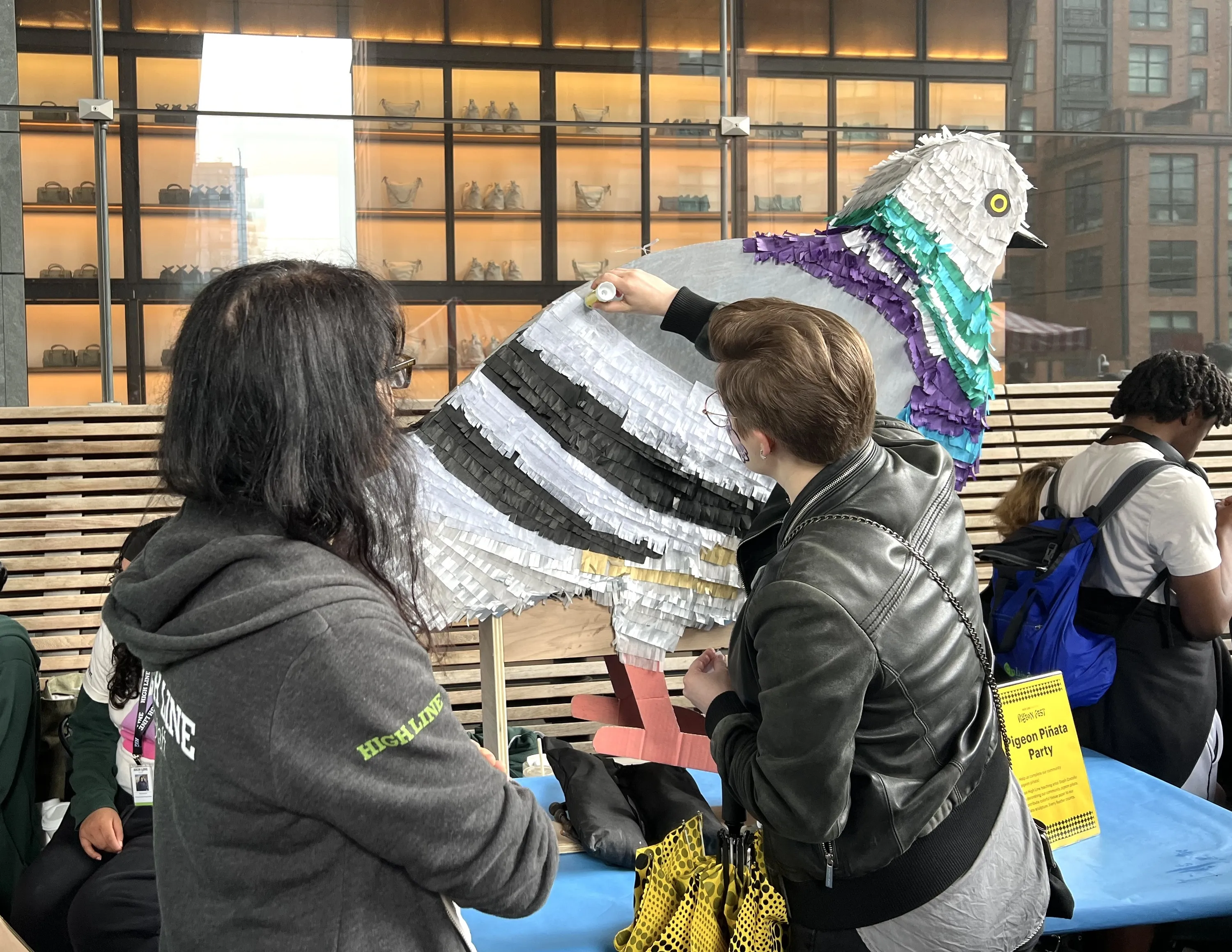 Two people help to create a pigeon pinata.