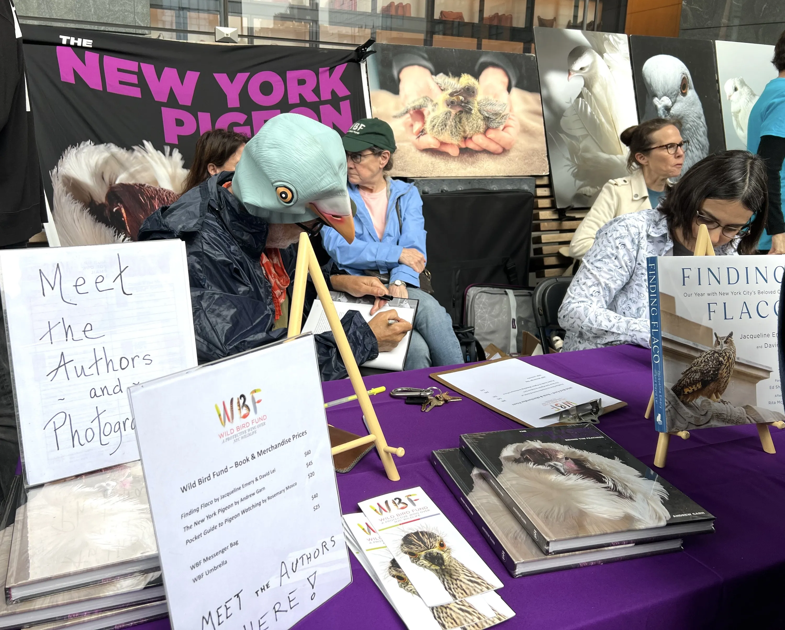 Local authors man a booth, including one person wearing a pigeon hat.