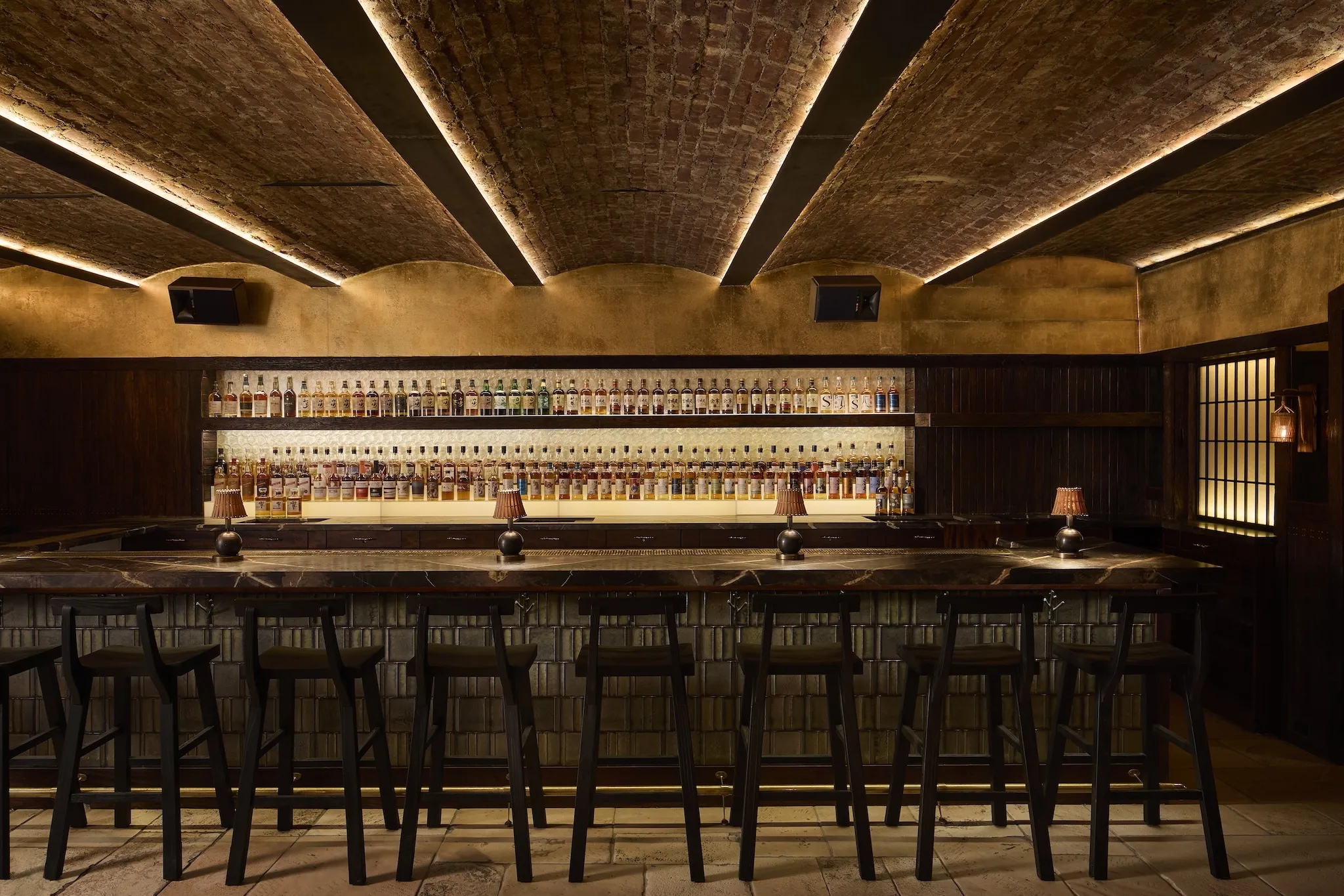 An illuminated bar with stools