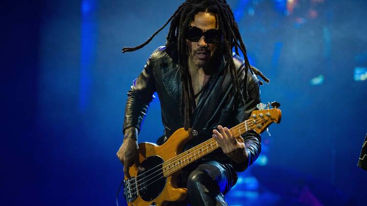 Lenny Kravitz performing on stage with a guitar 