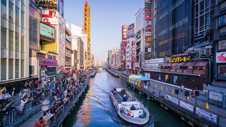 Osaka, Japan - March 13, 2019: Tombori River Cruise is sightseeing along the waterway trip about 20 minutes with a guide on Dotombori River. Tourists can learn about highlights and history from boat