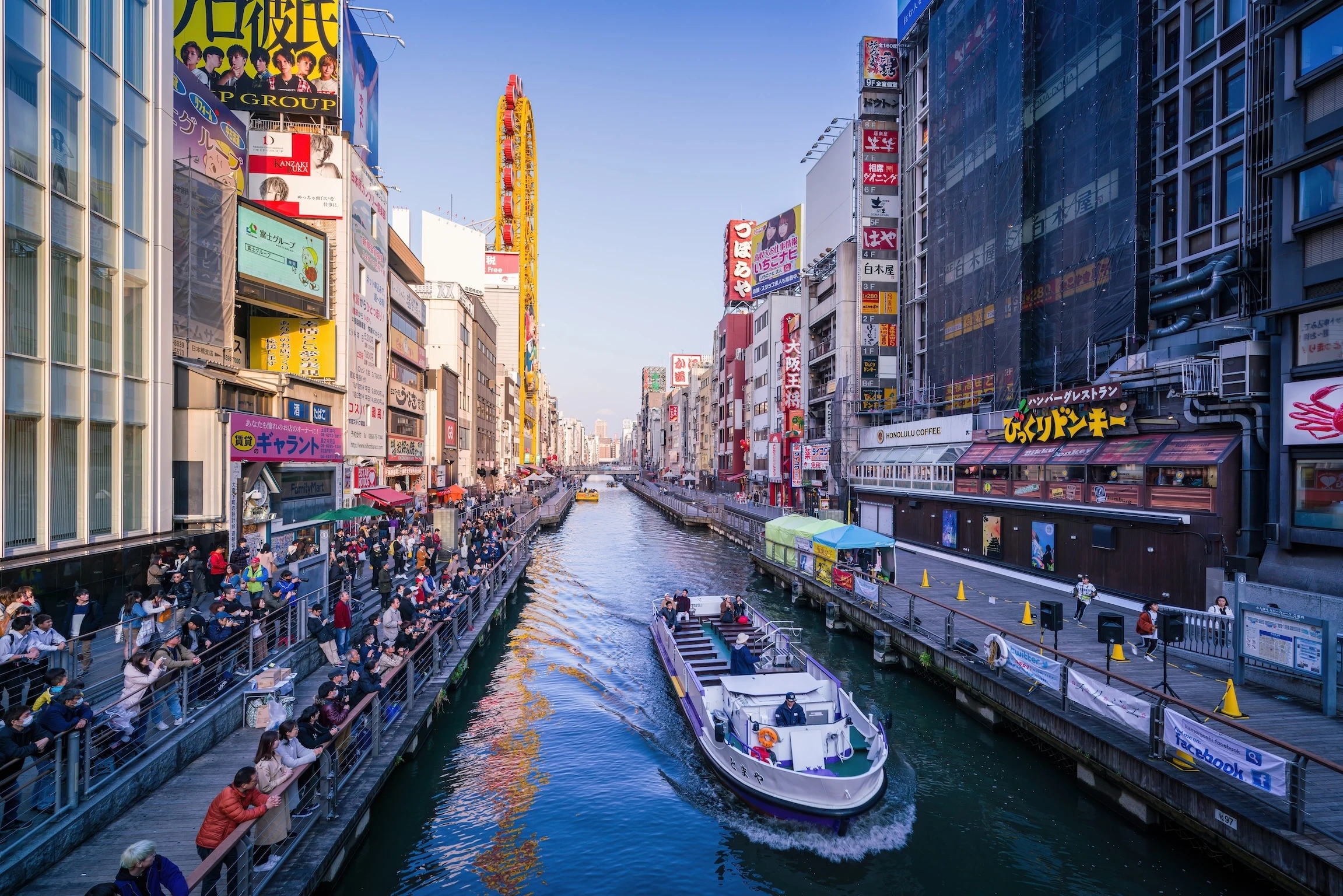 Osaka, Japan - March 13, 2019: Tombori River Cruise is sightseeing along the waterway trip about 20 minutes with a guide on Dotombori River. Tourists can learn about highlights and history from boat