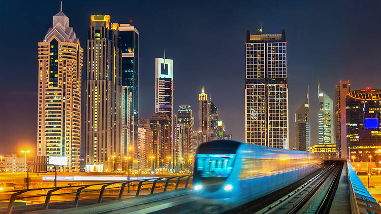 Dubai metro with city in background at night