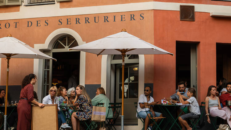 The exterior at Bistrot des Serruriers, showing people at tables with umbrellas 
