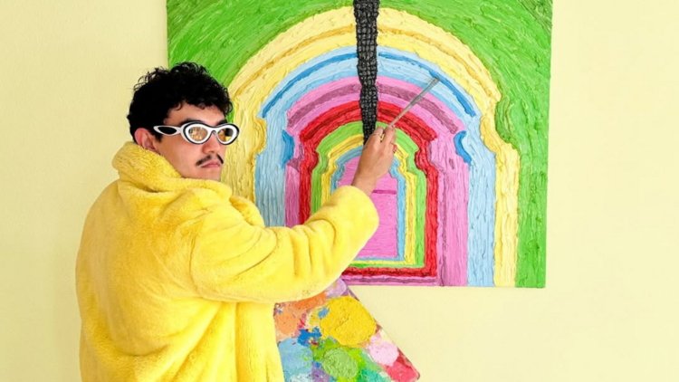El artista Emmanuel Carvajal con su obra