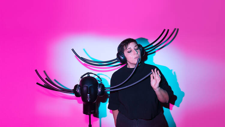 A woman singing into a microphone wearing headphones. 
