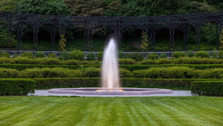 The recently restored Center Garden at dusk, showcasing the illuminated fountain and pergola