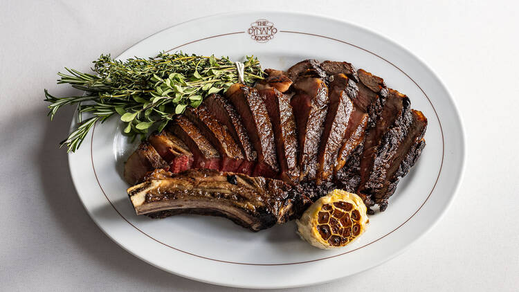 | A ribeye steak with herbs and cooked garlic