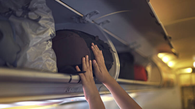 Hand baggage being stored on a plane