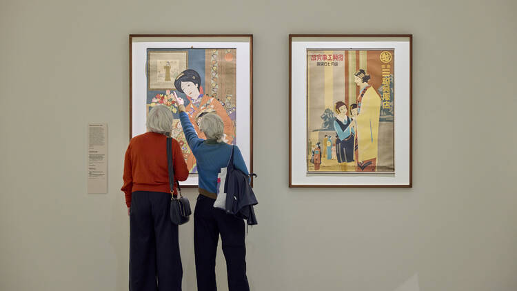 Two people admiring Japanese art.